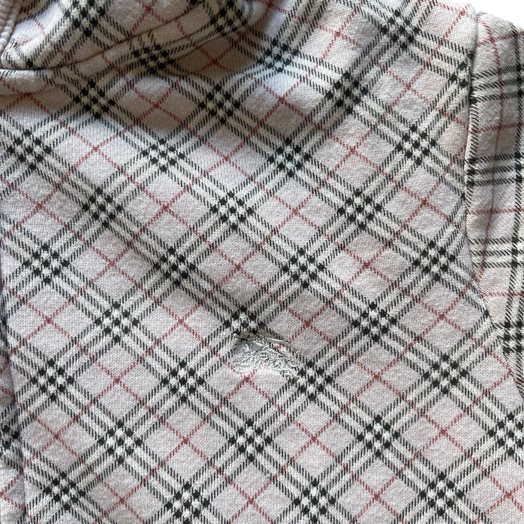 Sweat à capuche court zippé à motif tartan beige et gris, avec poches kangourou et finitions côtelées.