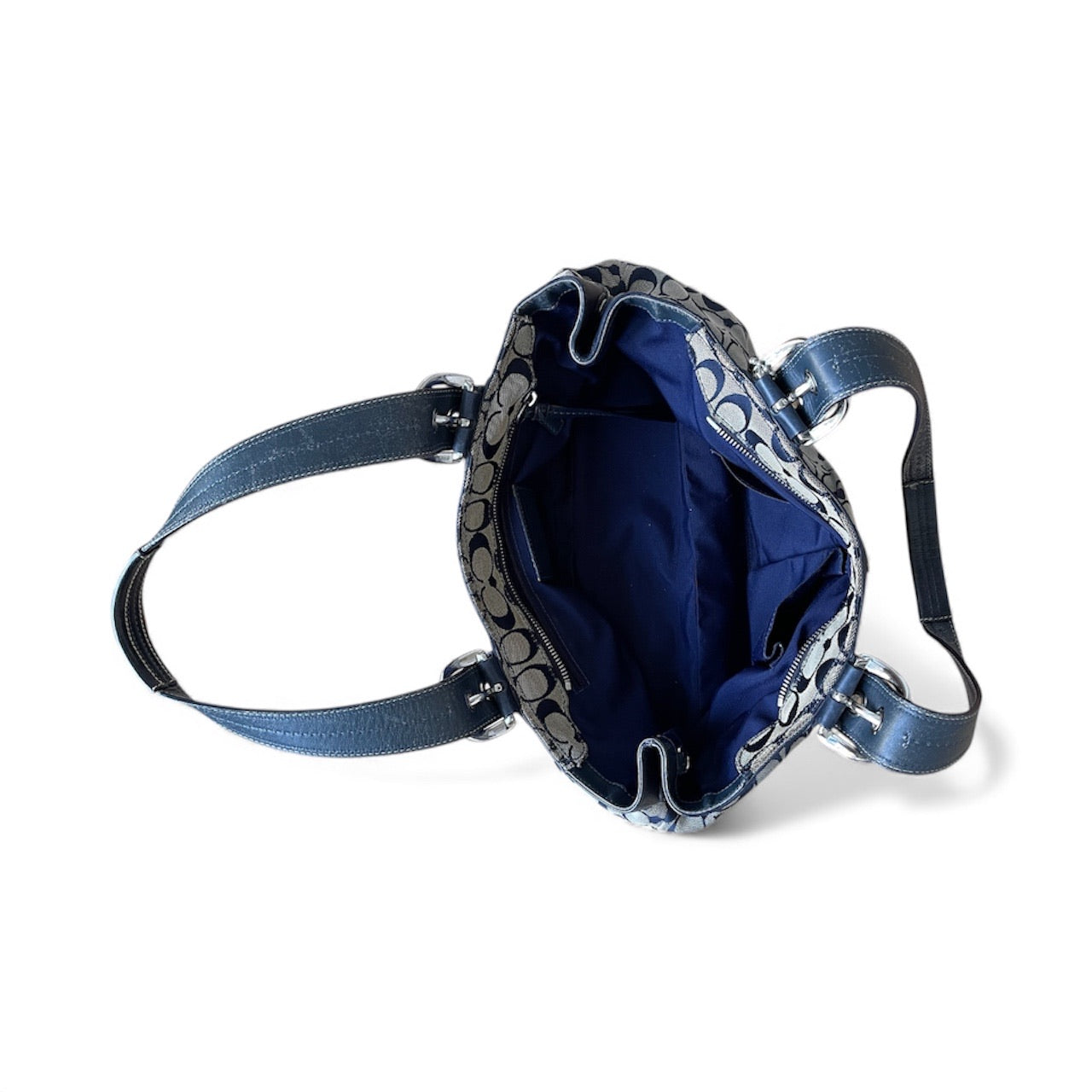 Sac à main Coach vintage en toile monogrammée beige et cuir noir, avec deux anses et boucles argentées, format moyen élégant.