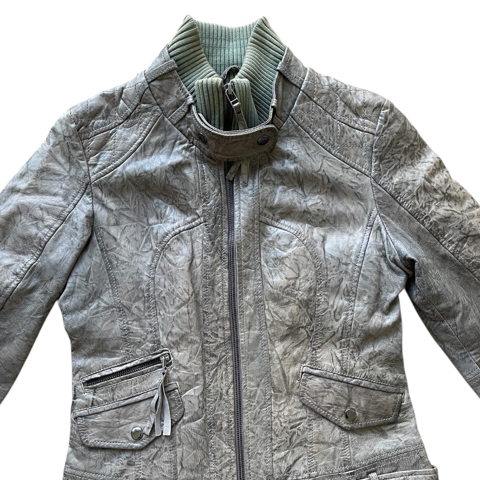 Veste en cuir vert avec col montant côtelé, fermeture zippée et poches à rabat et zippée sur le devant