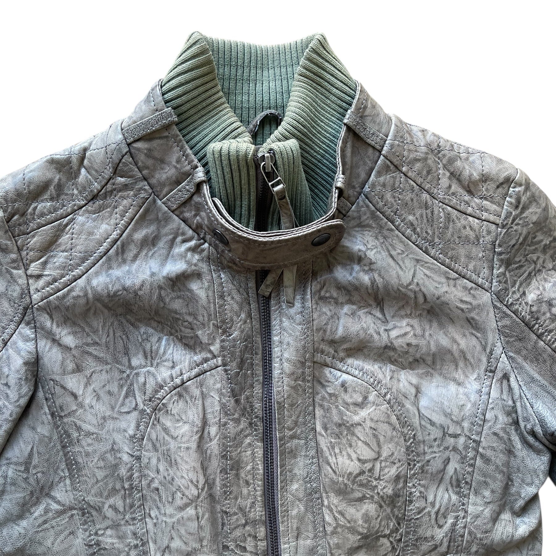 Veste en cuir vert avec col montant côtelé, fermeture zippée et poches à rabat et zippée sur le devant