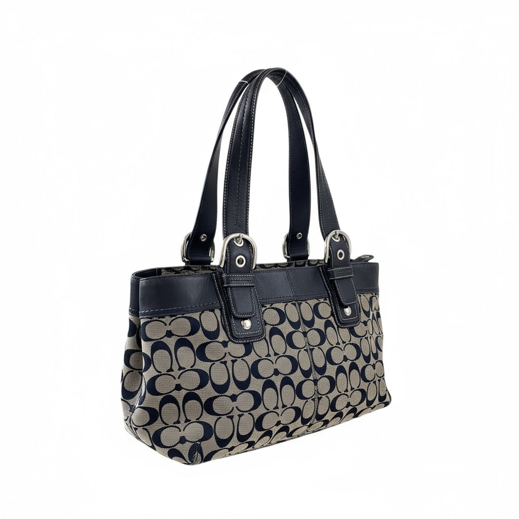 Sac à main Coach vintage en toile monogrammée beige et cuir noir, avec deux anses et boucles argentées, format moyen élégant.